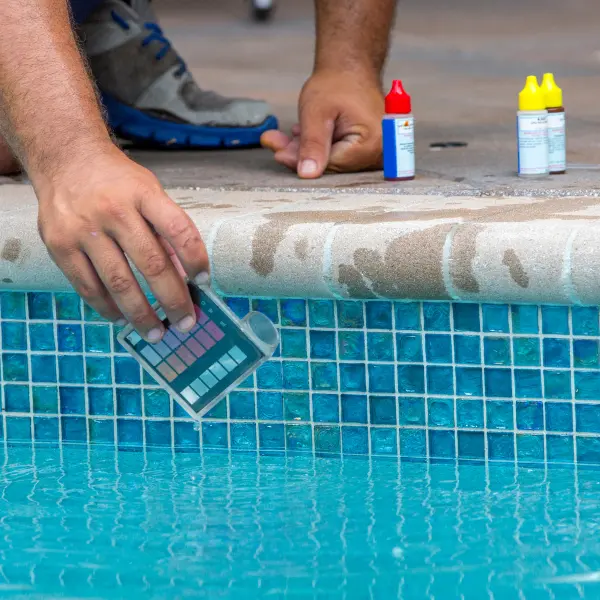Technician testing pool pH and chlorine levels
