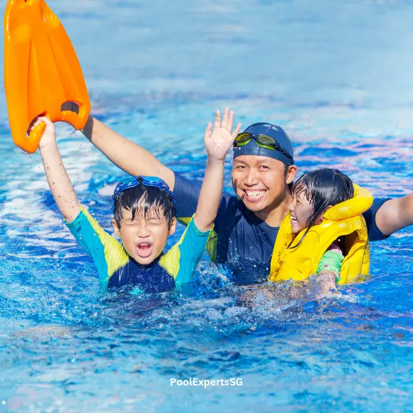 A dad and kids having splashing fun in a swimming pool